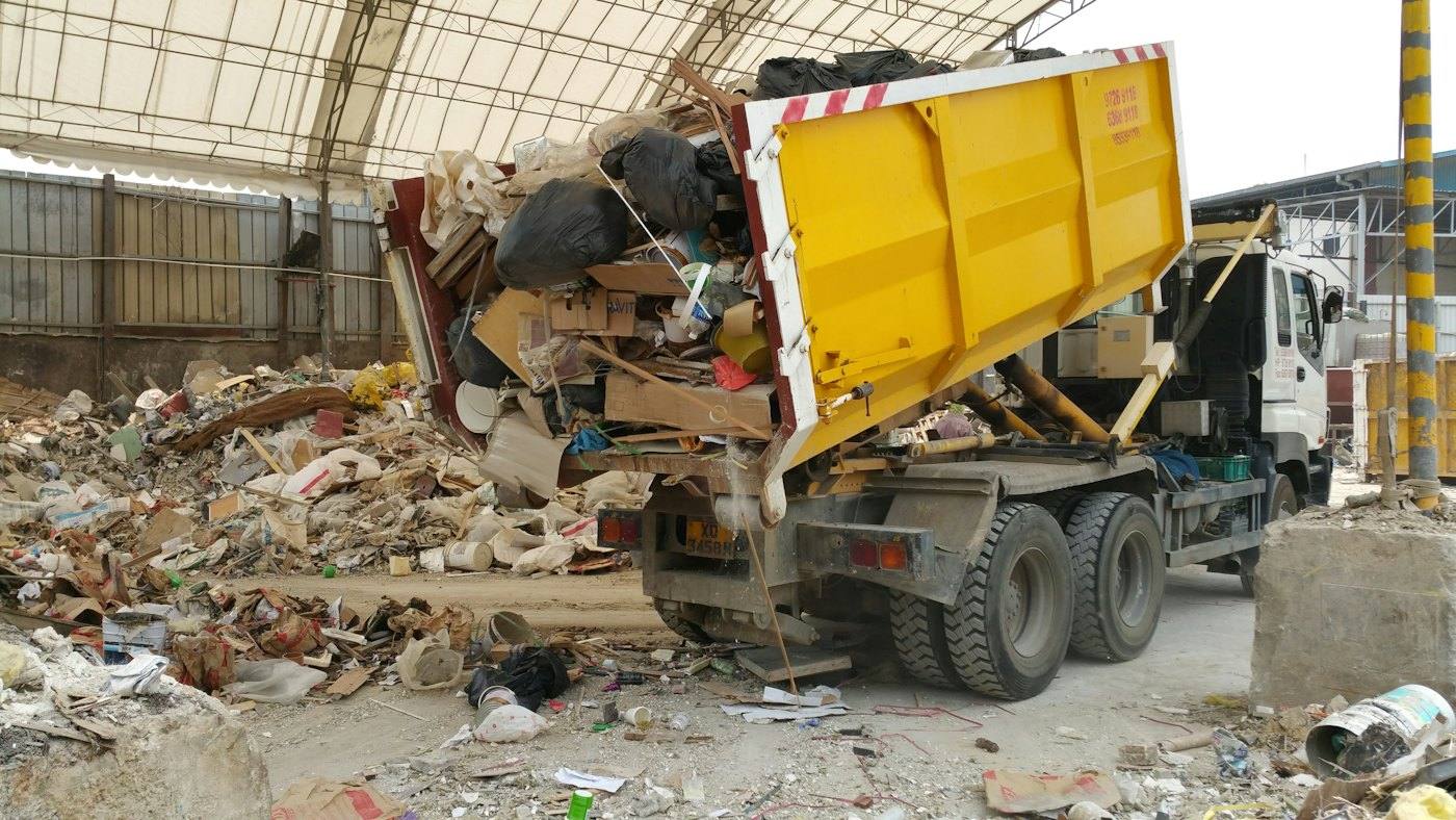 Camión descargando residuos en una nave de reciclaje